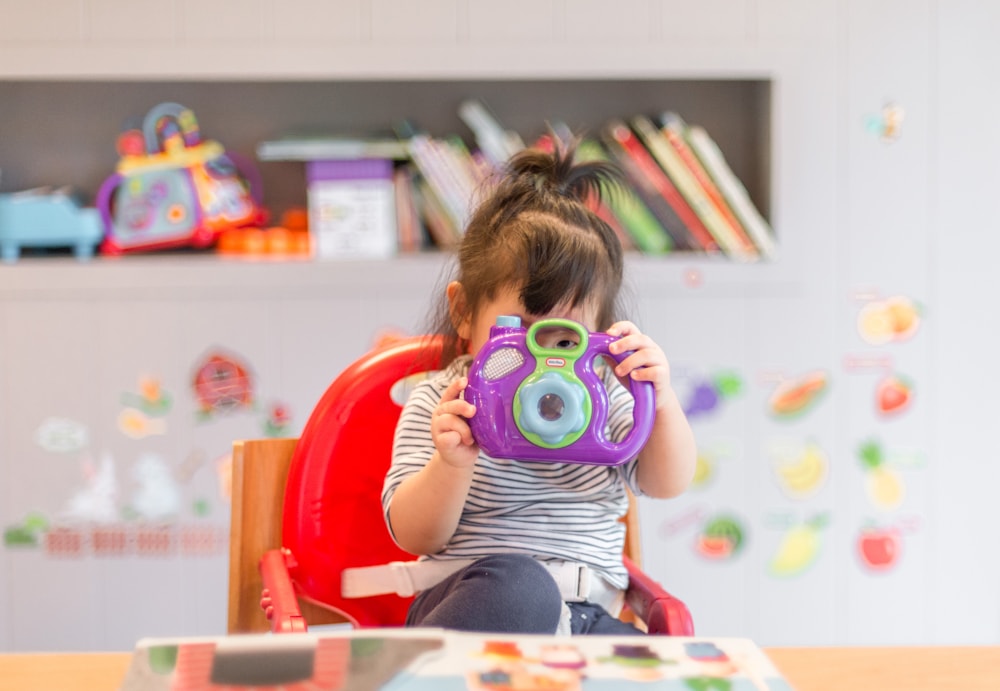 Criança brincando com uma câmera colorida
